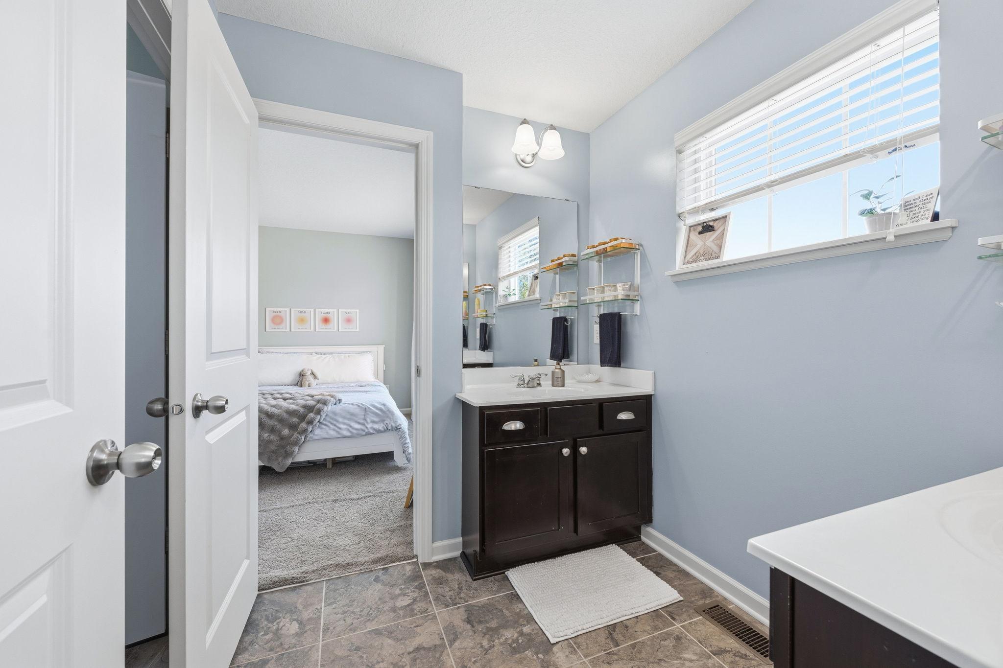 Convenient Jack-and-Jill style bathroom with dual access, oversized vanity, natural light, and functional layout designed for shared everyday living.