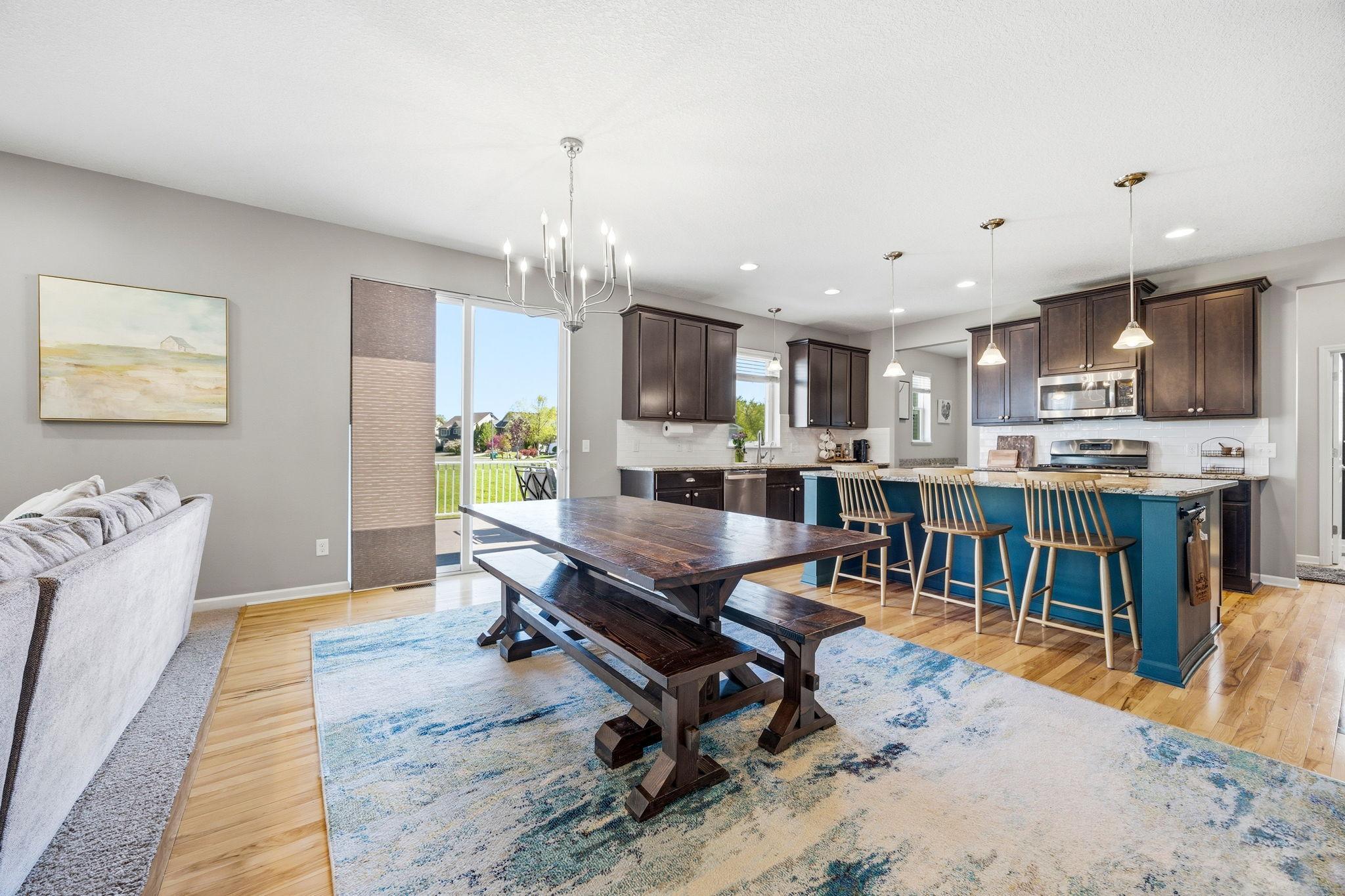 Sun-filled dining area flows effortlessly into the stunning kitchen and living space, featuring oversized center island seating and seamless access to outdoor entertaining.