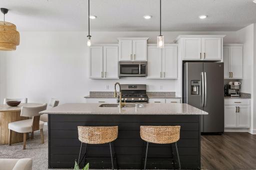 Kitchen with a large center island that has plenty of counter space. Here you can see the cabinet space as well with a possible coffee counter!