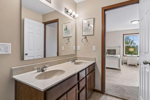 The bath has a large vanity with dual sinks with a tub and shower combination.