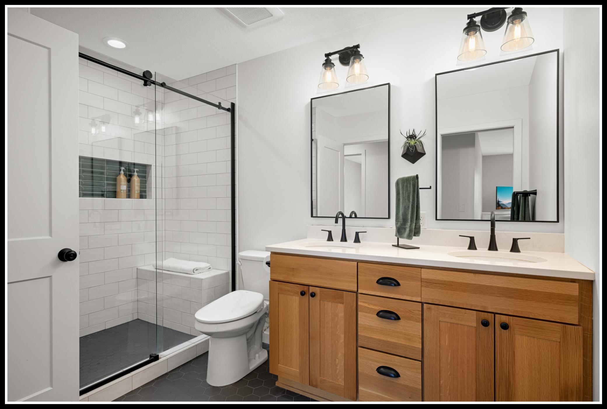 Double-sink vanity and walk-in shower in the upper level walk-thru bathroom