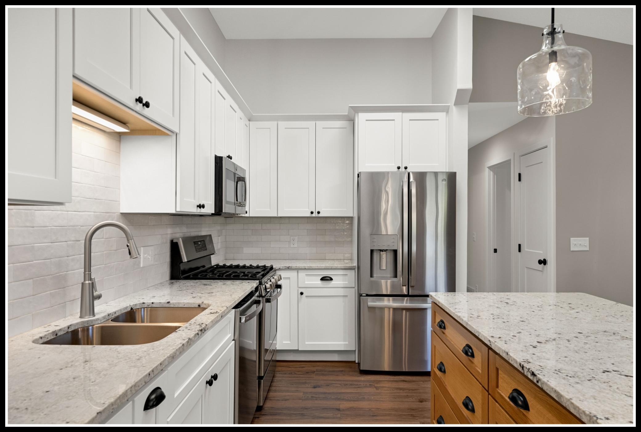 Granite counters, tiled backsplash, and stainless steel appliances