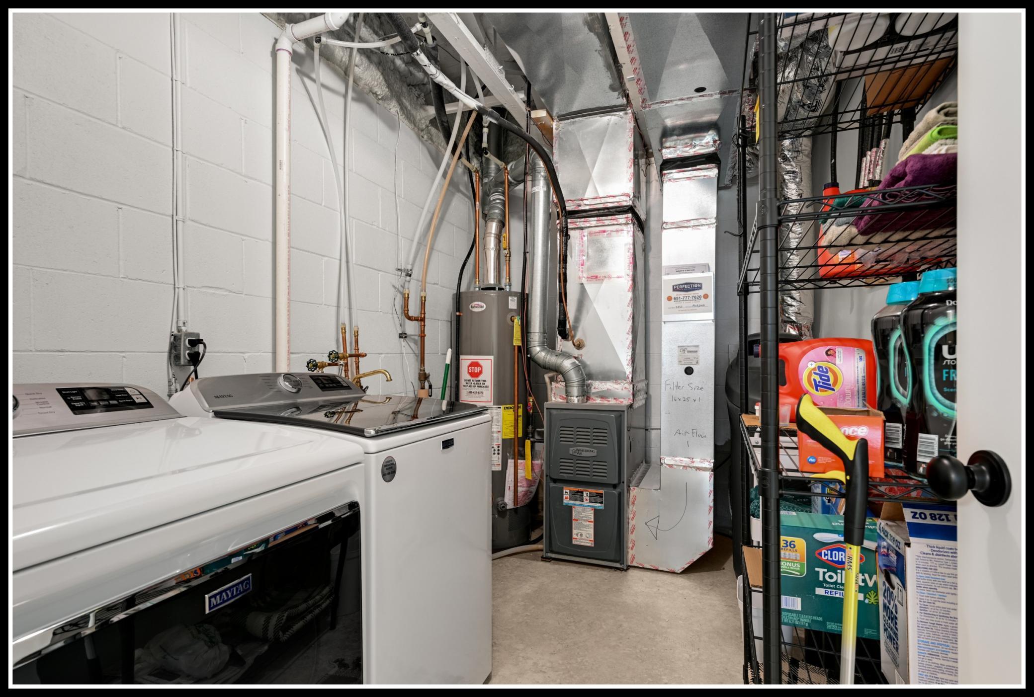 Neat and clean utility room houses the washer and dryer to storage space to spare