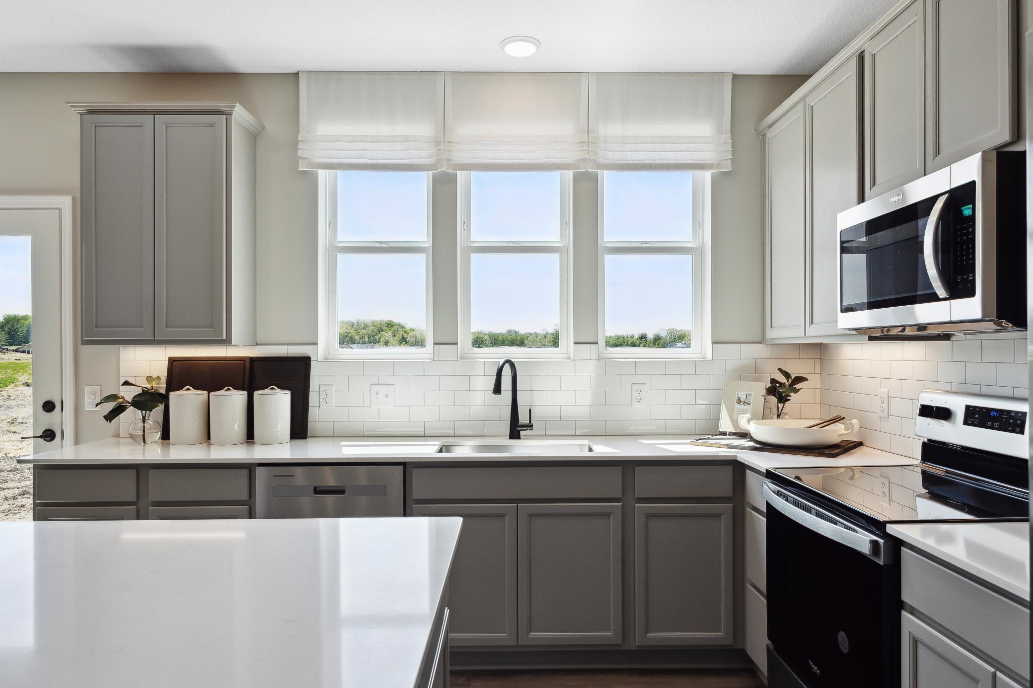 Kitchen with three windows to the backyard
