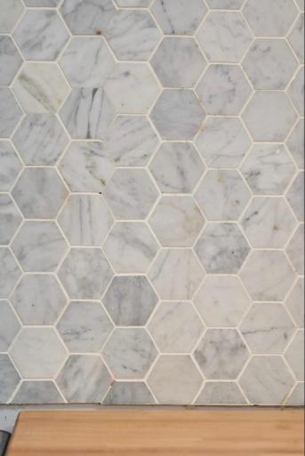 The cheery on-trend kitchen boasts a great backsplash of mosaic marble tile! Looks great with butcher block counters!