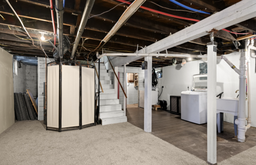 Find a photo of the laundry area has a cellar or workshop in back. There is an additional storage room and great storage under the stairs!