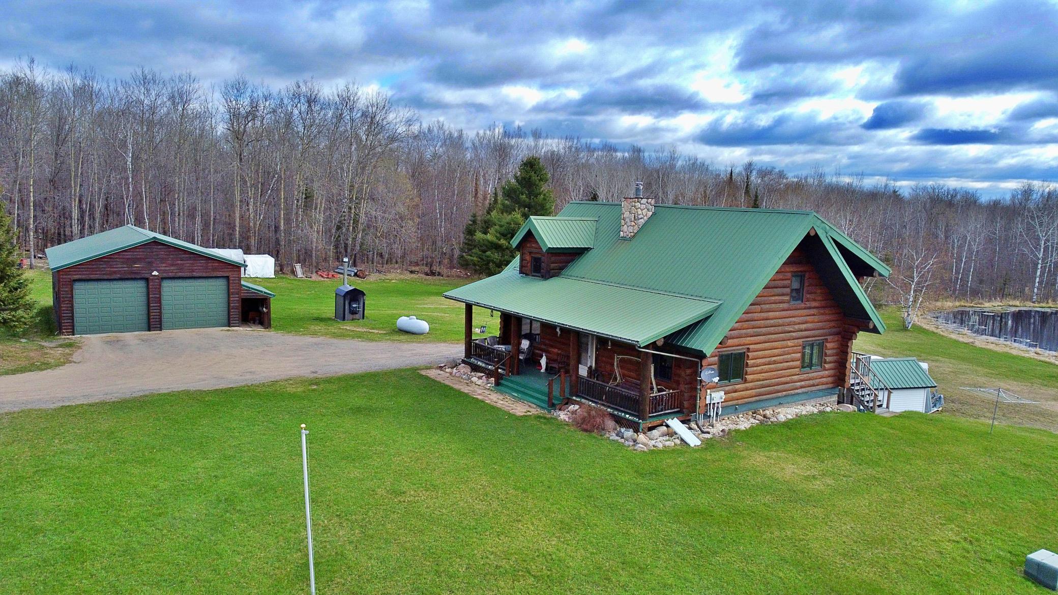 Propety view of log home garage and pond.jpg