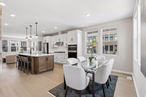 A large center island kitchen with bar seating, gas cooktop, wall oven and generous cabinetry.