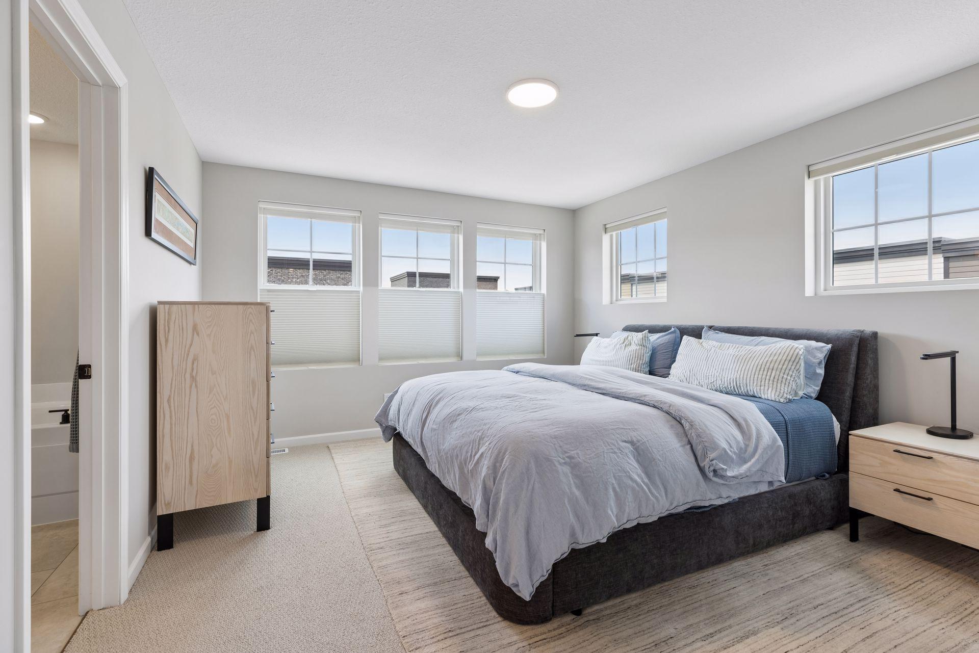 A spacious primary suite with a rare & highly desirable ensuite bath featuring both a soaking tub and separate shower, a feature not commonly found in many units within the community. Custom window treatments with darkening shades in the primary.