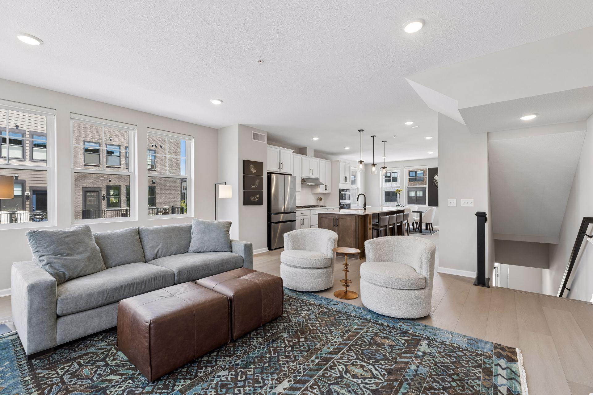 The main living level features an open-concept design with abundant natural light. Custom window treatments throughout and remote shades in the living, kitchen, and dining areas.
