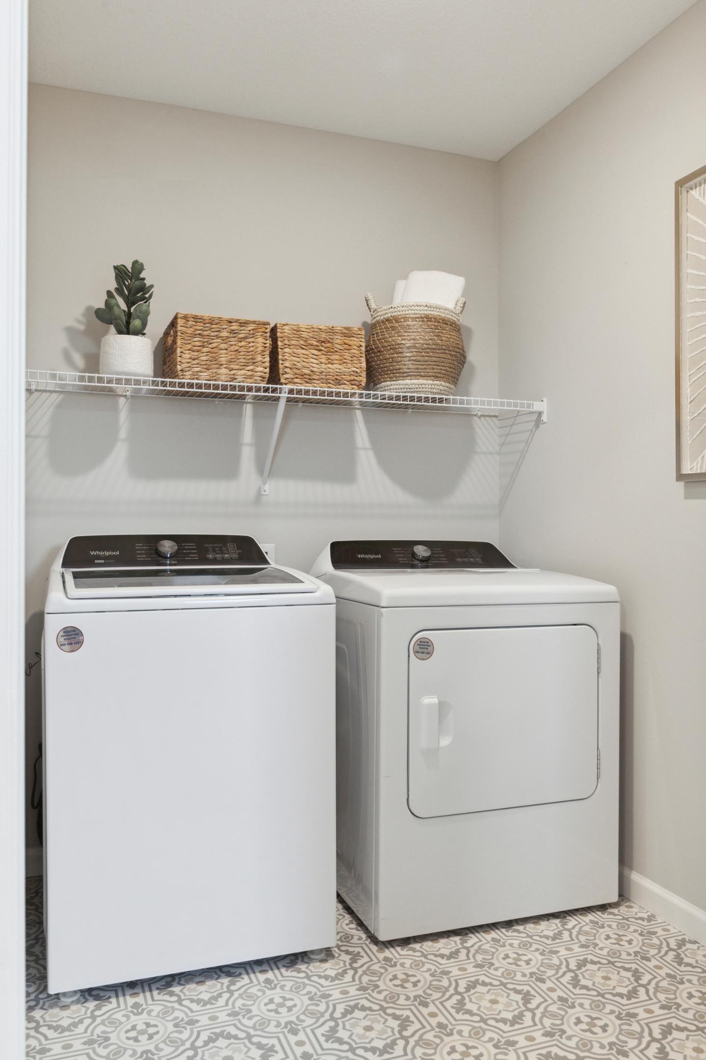 Conveniently located off the primary suit the laundry room is both functionally placed and spacious! Photo of model home.