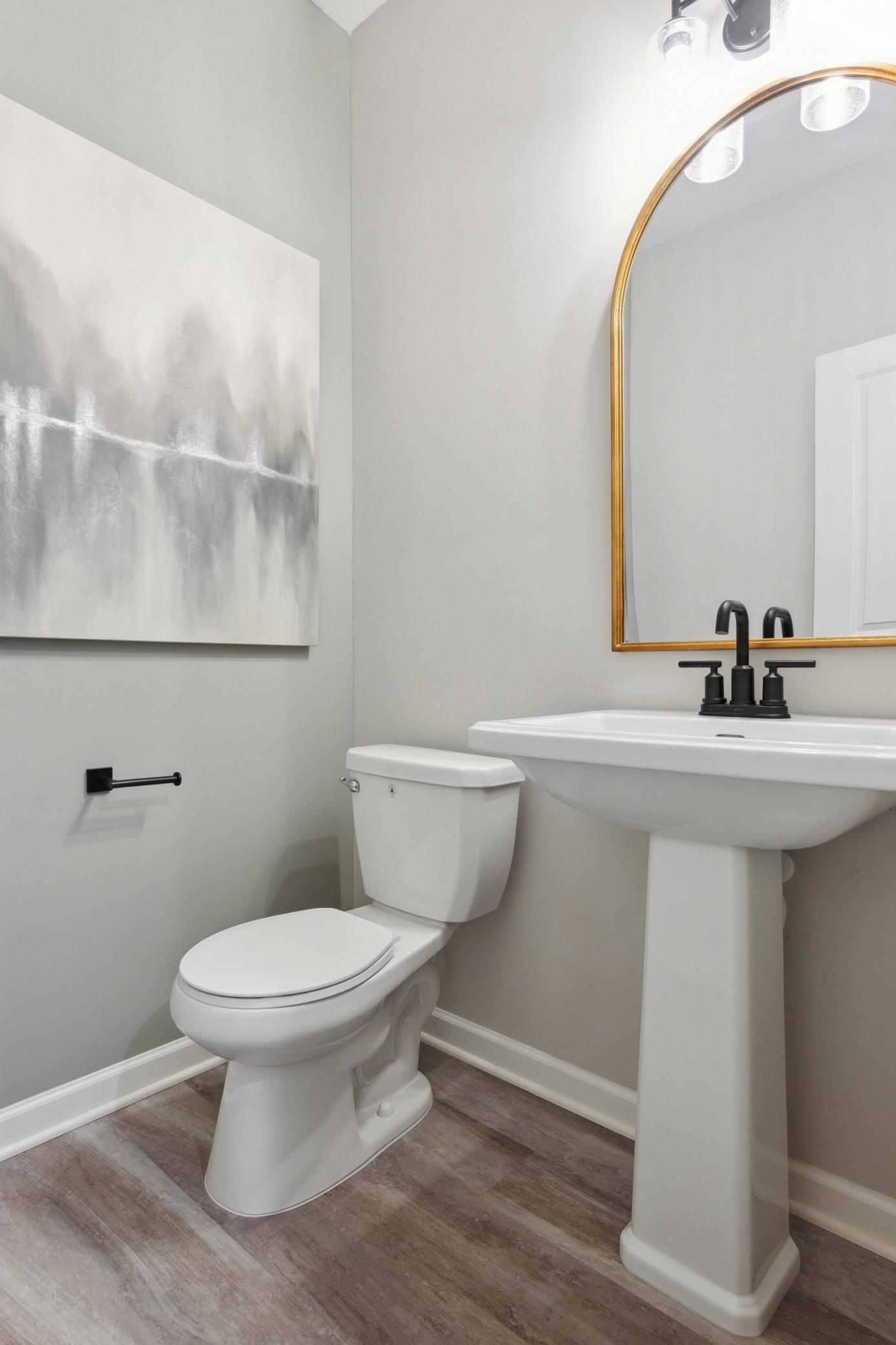 Main level also features a luxurious half bath tucked away by the entrance from your front door! Photo of model home.