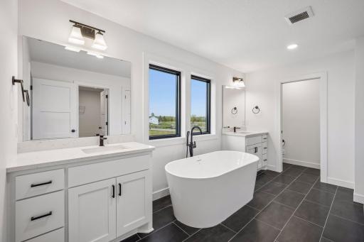 Private primary bathroom with dual sinks, soaking tub and walk-in shower