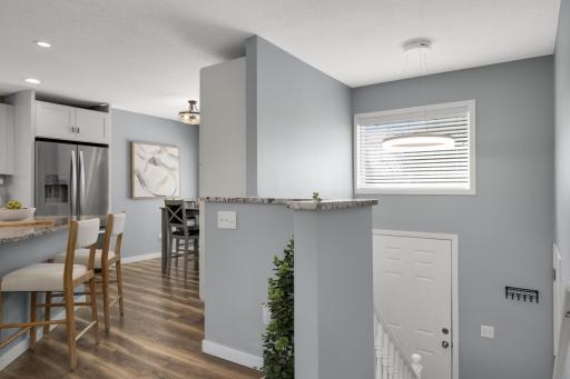 The front foyer offers a bright, clean, and welcoming first impression with a modern neutral color palette and an open-concept feel. Soft gray walls paired with crisp white trim & doors create a fresh, updated look with updated lighting