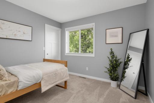 This home features 4 bedrooms. 2 upstairs and 2 downstairs. Both upper level bedrooms have walk in closets. Natural light pours through the large window, offering peaceful views of mature greenery outside and making the room feel airy and serene.
