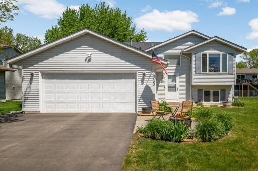 The home features a two-car attached garage, large front bay window and a welcoming front entry accented by a curved flower beds and a small seating area. Cozy & Welcoming