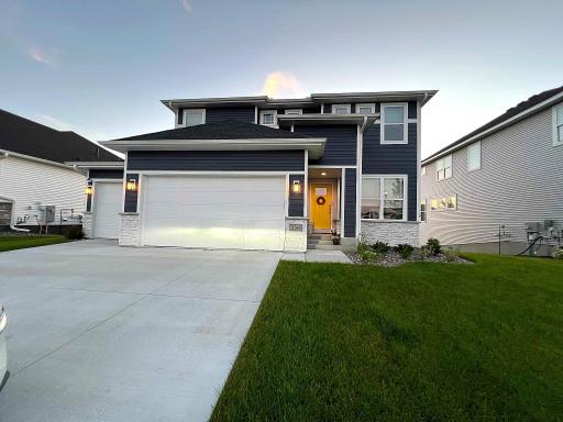 Stunning two-story home showcasing modern curb appeal, a warm welcoming entry, and an expansive three-car garage.