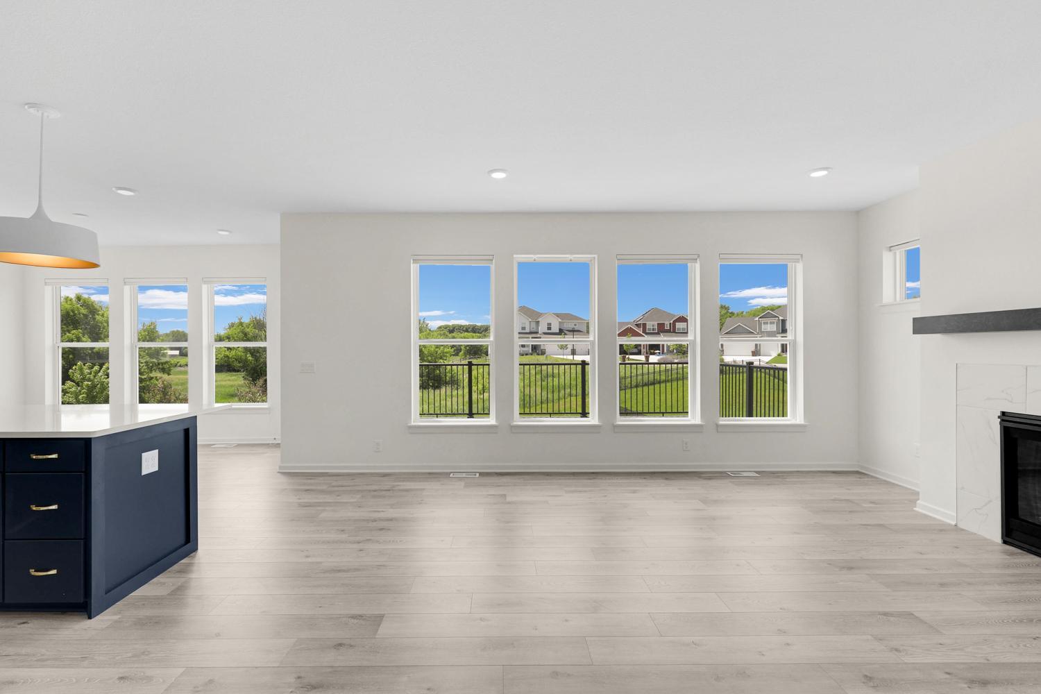 Wall of oversized windows in the living room, with views of nature in the back yard.