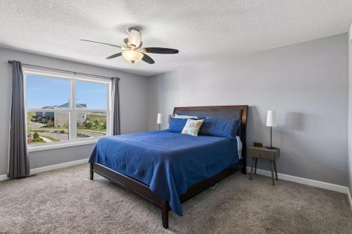 The primary suite includes a walk-in closet and spa-inspired bathroom featuring dual vanities and a large tiled shower.