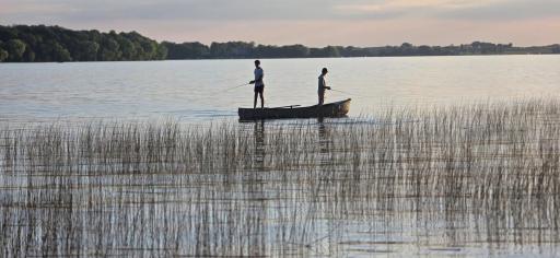 Photo of family members fishing near the shoreline. Many fish stories are waiting to be told.