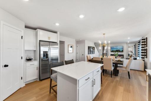 Open concept kitchen, dining, and family room give the home a light and airy feeling. Photo of model home, colors and finishes may vary.