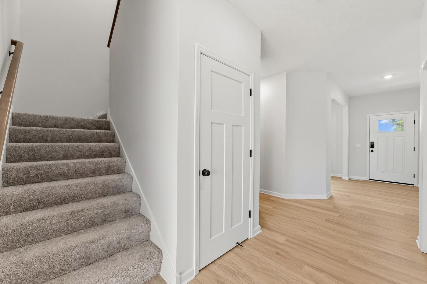 Front entry and stairs to upper level/door to basement