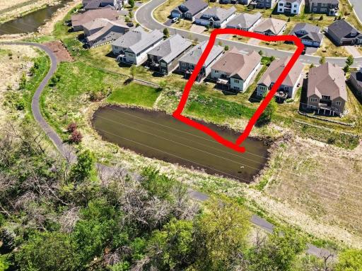 Aerial view of pond and home with walking trail path, too!