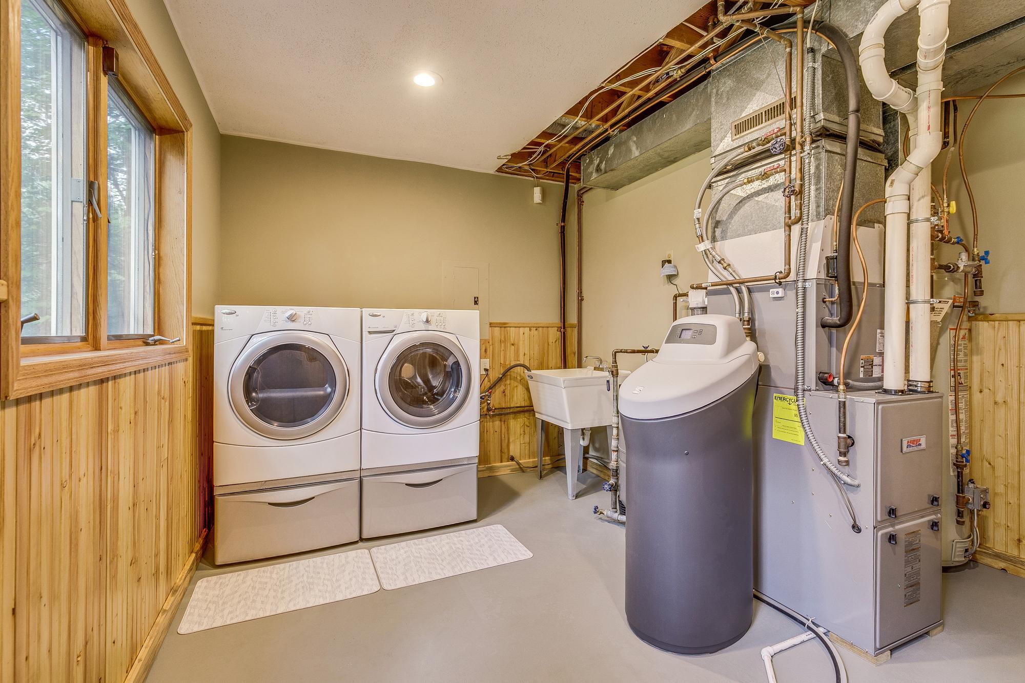 Huge Laundry & Mechanical Room with door to walkout to deck. New Front Load Washer & Dryer with Pedestals. Newer 96% High Efficiency Furnace & AC and New Water Softener.