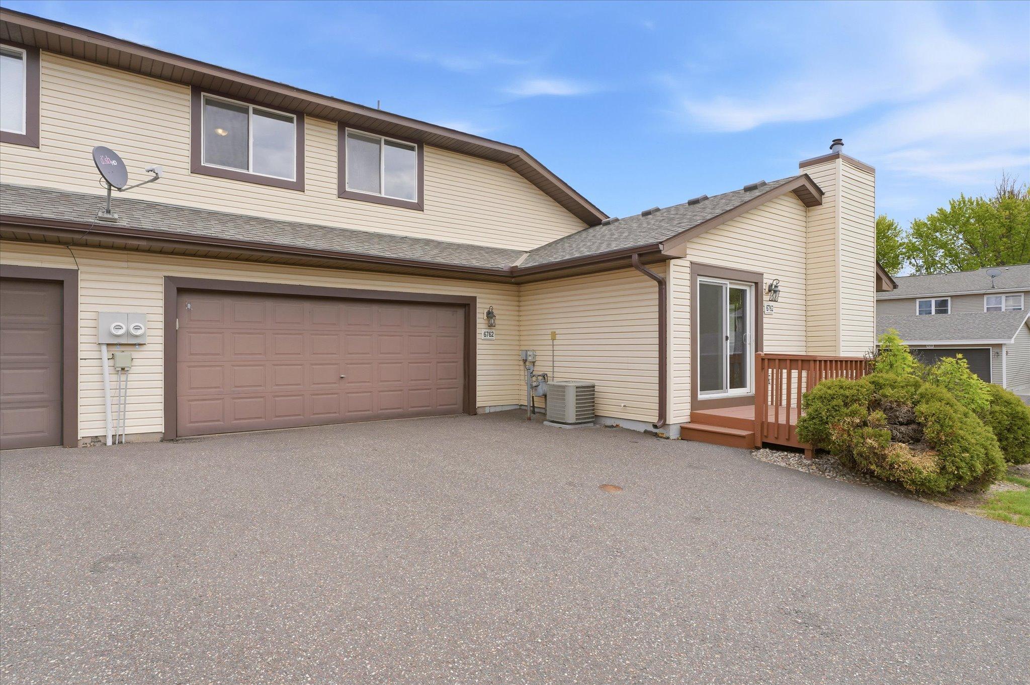 Private driveway and attached garage with easy access into the home plus a nearby deck perfect for relaxing outdoors.