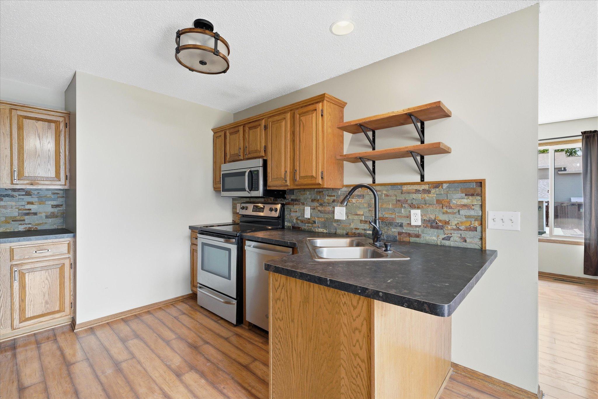 Efficient kitchen layout with plenty of prep space, oak cabinetry, and easy flow into the living and dining areas.