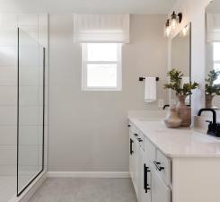 Perfectly located off the bedroom is the Primary Bathroom. This bathroom features modern finishings such as white cabinetry with quartz countertops mixed with the comfort of your double sink vanity and roomy shower. Photo of model home.