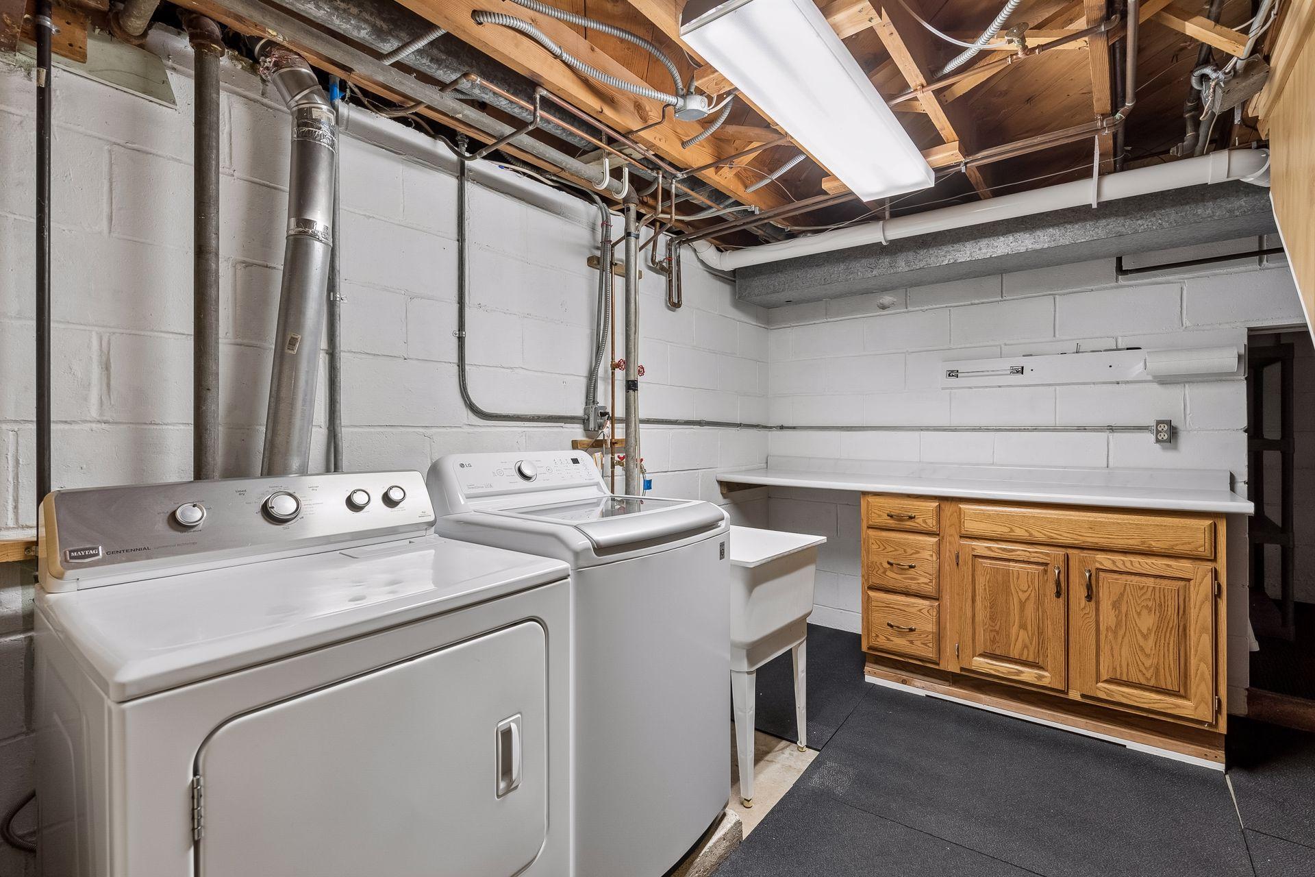 Newer washer/dryer, cabinetry in laundry room.