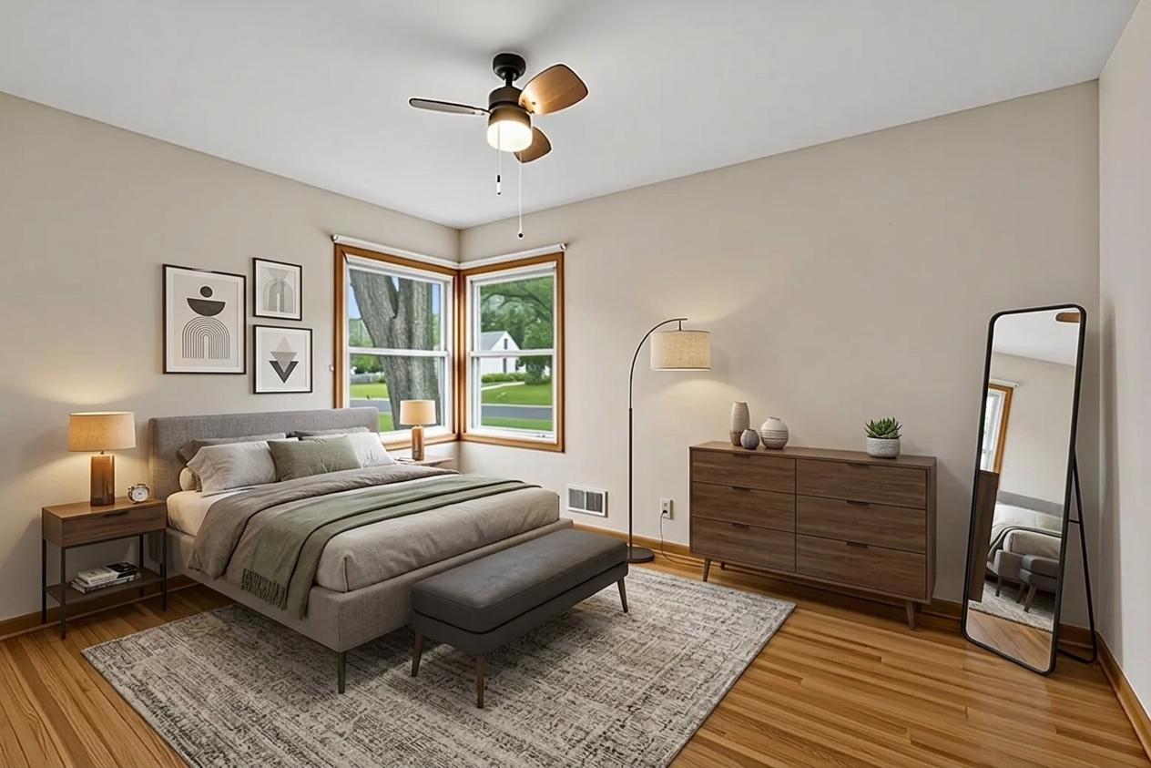 Primary bedroom has lots of natural light, hardwood floors and ceiling fan. Virtually staged