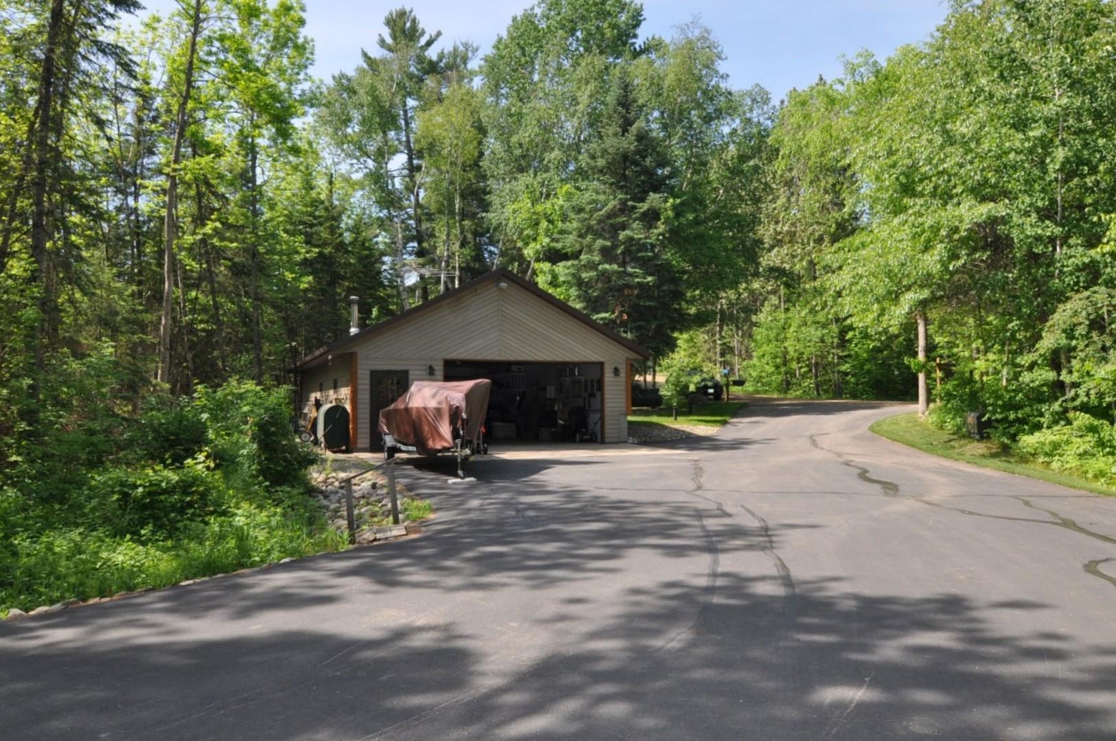 View of driveway from attached garage to detached garage and to road