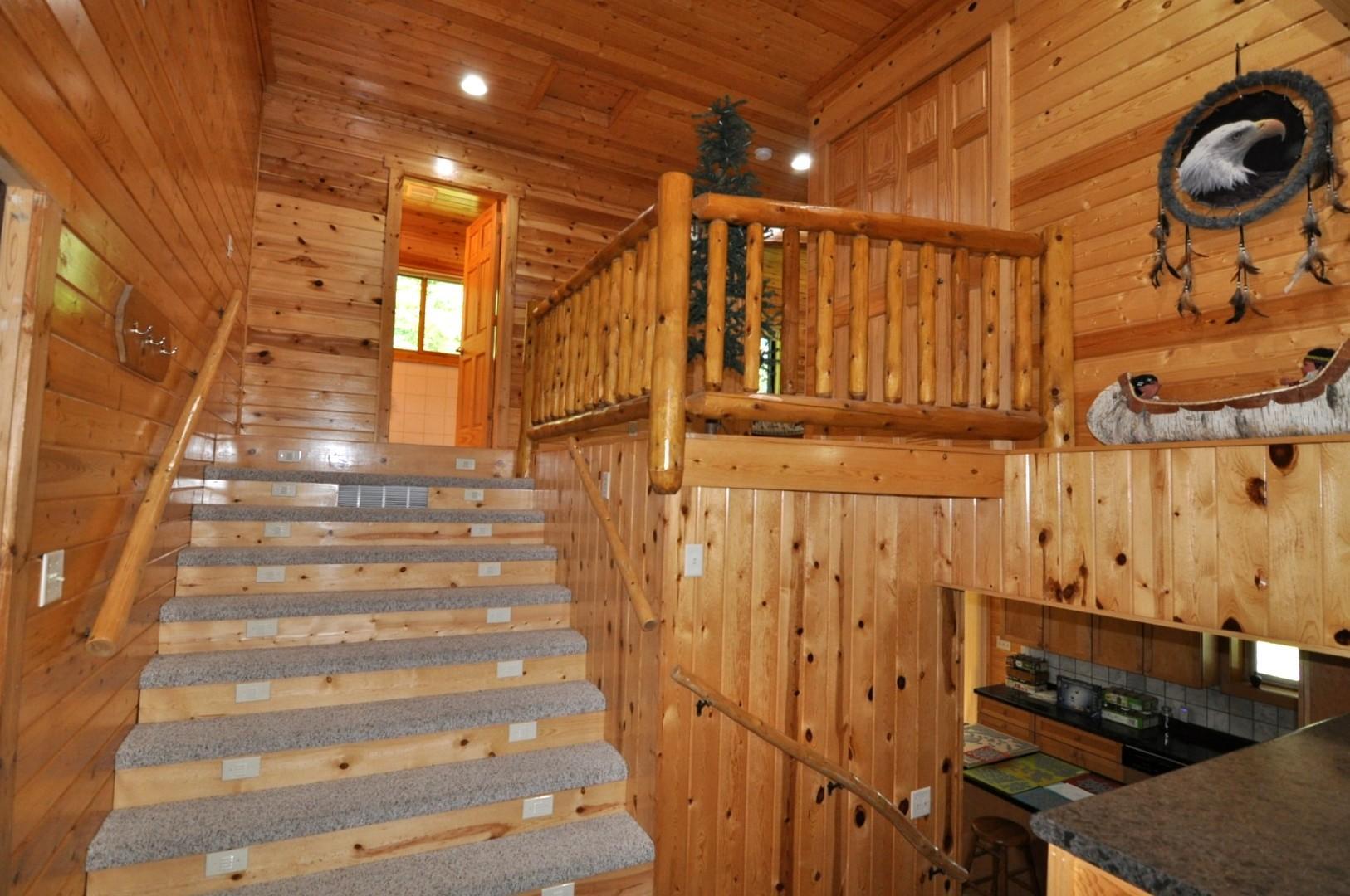 Wide, lighted stairs lead to the upper bedrooms and bath