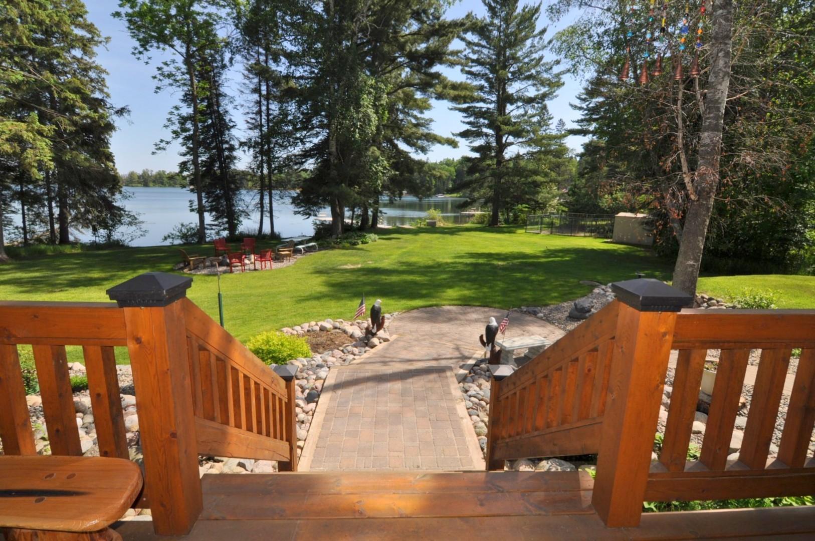 Stairs lead to paver sidewalk and grass to lakeside