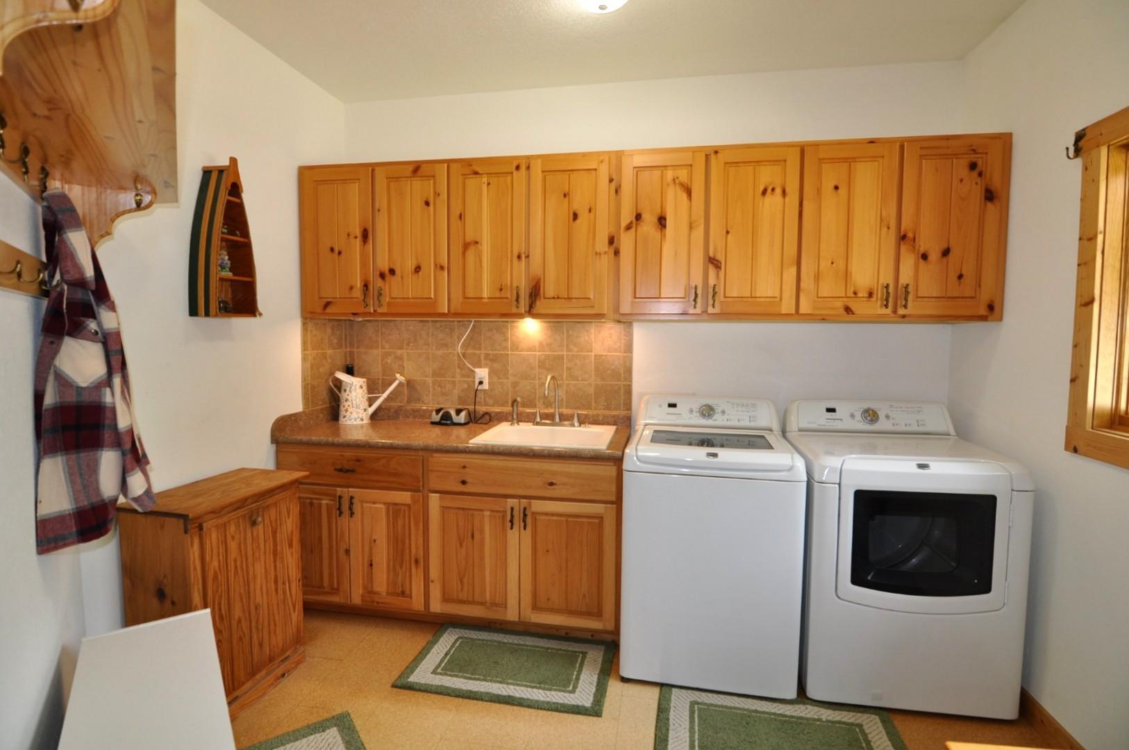 Laundry room with Knotty Pine cabinetry, Sink, Washer/Dryer