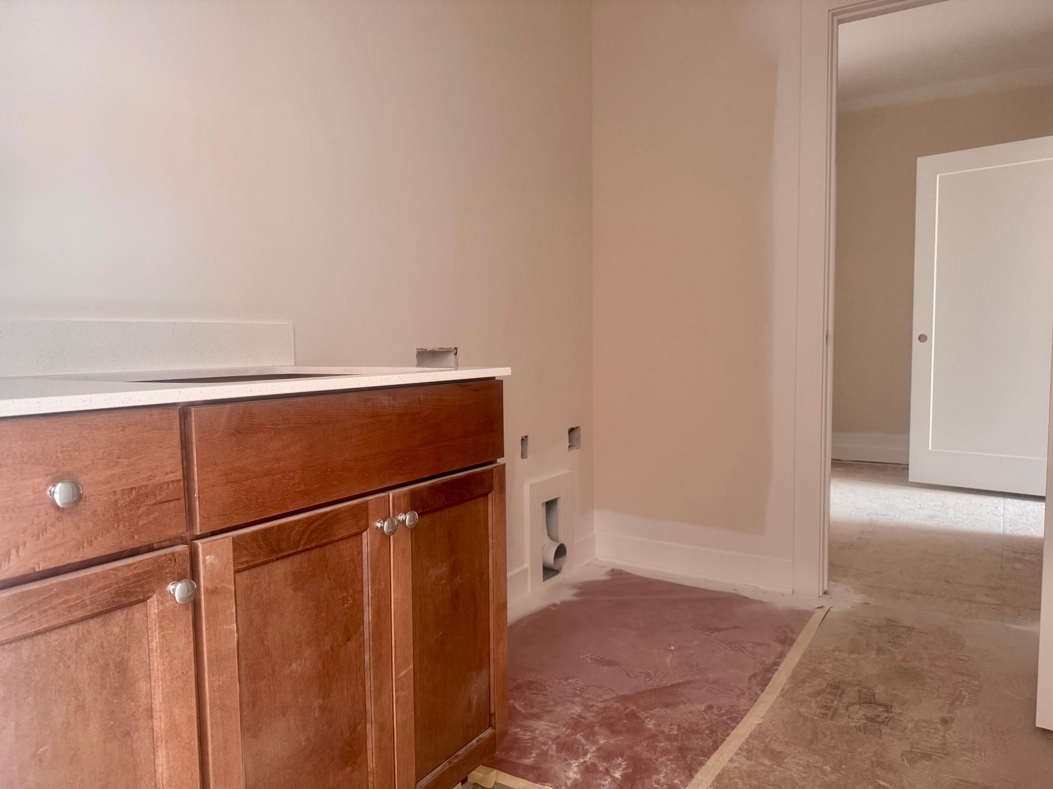 Progress photo of the laundry room with cabinet and sink