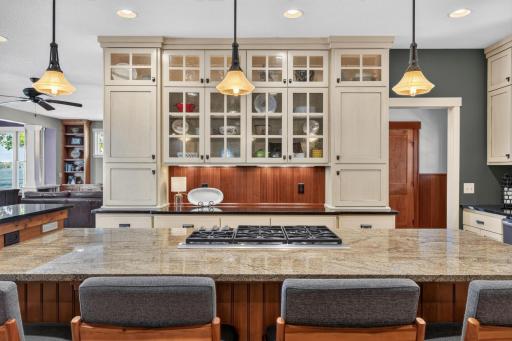 "Eat-In" center island boasts alder cabinetry, bead board paneled front with corbels and open display shelving