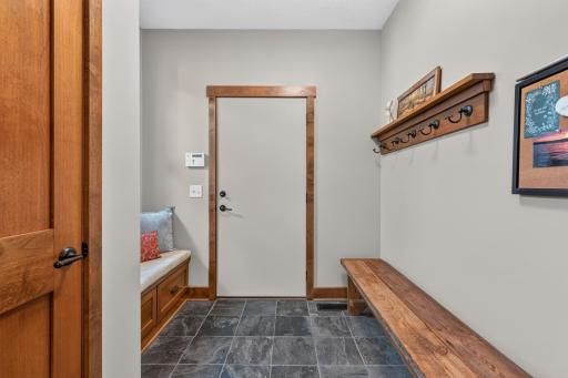 Mud Room features slate tile flooring at garage entrance and built-in bench with storage
