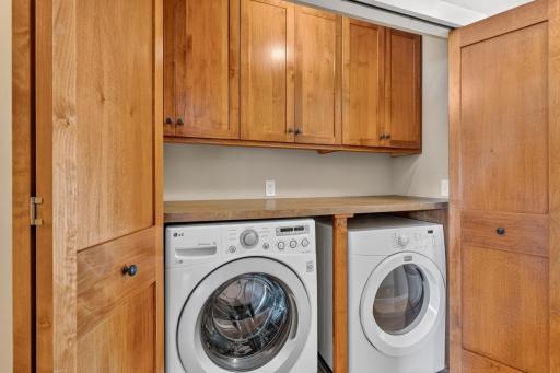 Laundry closet is centrally located and offers a large folding counter