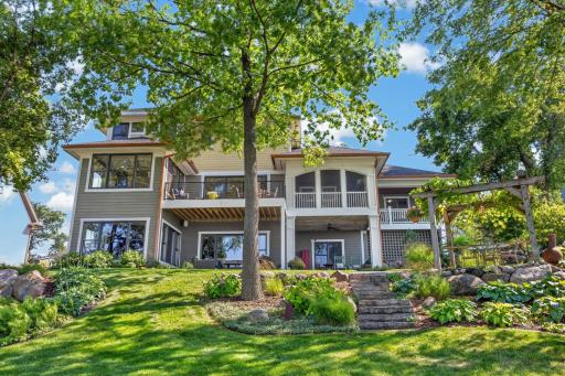 Additional patio is carefully placed to take advantage of lakeside views and features a pergola surround with mature grapevines accents
