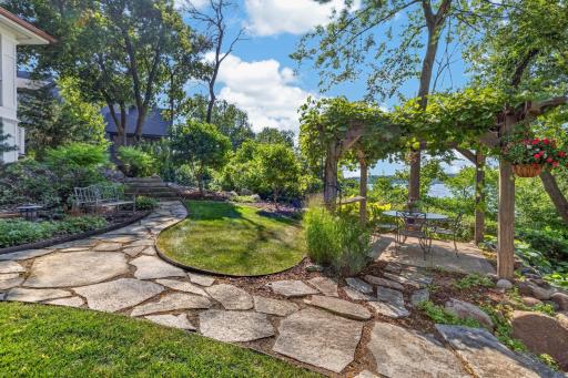 Natural stone walkways meander through mulched gardens and connect outdoor living spaces