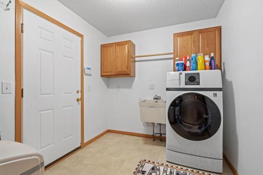 Convenient laundry and mud room located just off the attached garage, featuring an amazing smart washer/dryer combo. No more remembering to move clothes to the dryer â control everything right from your phone with the touch of a button.