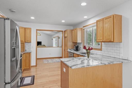 Open kitchen featuring beautiful granite countertops, warm oak cabinets, and a functional layout.