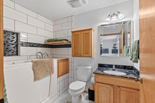 Private ensuite bathroom featuring extra storage and a safe, relaxing soaking tub perfect for unwinding at the end of the day.