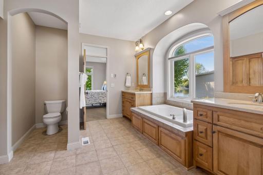 A well-appointed primary bath with heated floors, walk-in shower, dual vanity, and an adjoining walk-in closet