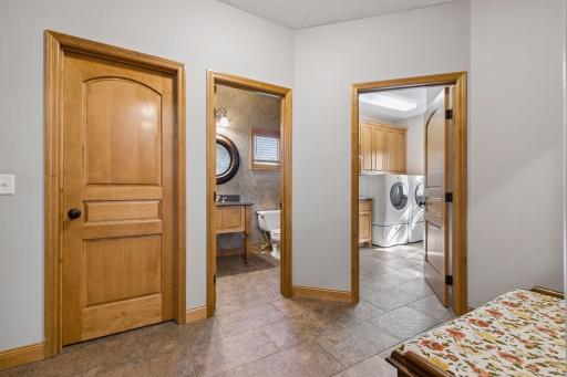A well-appointed mudroom off the three-car garage, complete with walk-in coat closet, laundry, and powder room