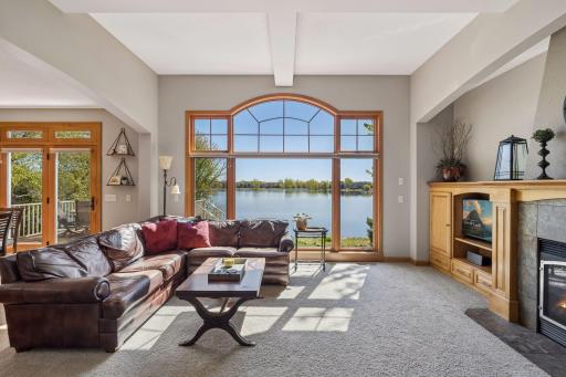 Upon entry, expansive living room windows frame stunning views of Sunrise Lake