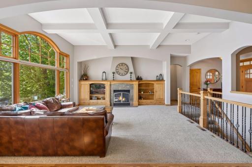 A coffered ceiling and custom built-ins ground the living room, while expansive windows draw in views of Sunrise Lake